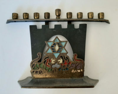 חנוכיה ישנה לא מצויה תוצרת ישראל. דימוי אריות בפתח שער. צבועה בצבעים המקוריים. גובה כ 14.5 ס"מ. 