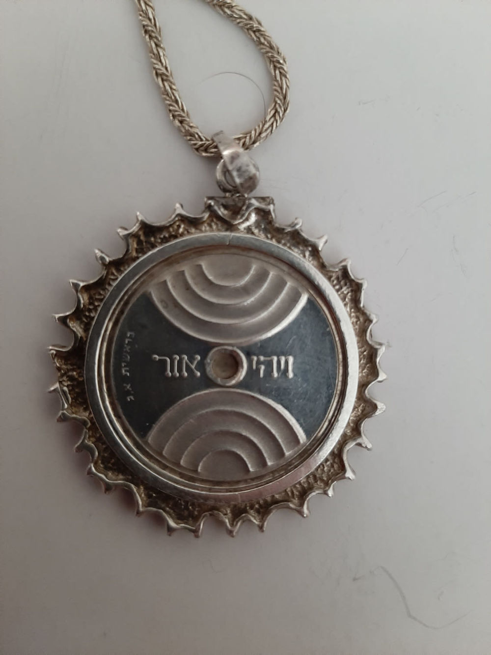 תליון כסף, מדליה "ויהי אור" של האמן הידוע יעקב אגם. שרשרת עבה. קוטר התליון 30 ס"מ. אורך השרשרת 