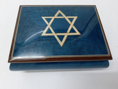 קופסה תיבת נגינה לתכשיטים עשויה עץ מחופה בצבע כחול עם מגן דוד. כשפותחים היא מנגנת את המנגינה 