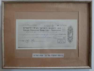 צילום שיק תרומתו האישית של נשיא המדינה זלמן שזר לישיבות בני עקיבא משנת 1971 ממוסגר ומחוםה בזכוכית.