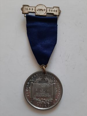 מדליה יהודית שהוענקה ל E.Levin. שנת 1905. מאחור מנורה והכיתוב "נר מצווה ותורה אור" בעברית. קוטר 