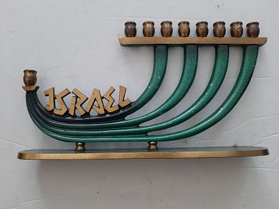 חנוכיה וינטג' לא מצויה, עשויה ברונזה צבועה פטינה ירוקה. הכיתוב ישראל באנגלית. גובה כ 12.5 ס"מ 