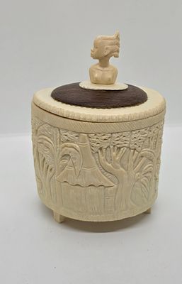 קופסה מיוחדת משן - הב בשילוב עץ. עם דמות של אשה אפריקאית על המכסה. עם גילופים של נוף כפרי. 