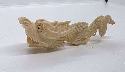 דרקון סיני מגולף בחומר טבעי. גילוף מפורט. הקשקשים מפורטים אחד אחד. נראה כאילו ממש בתנועה 