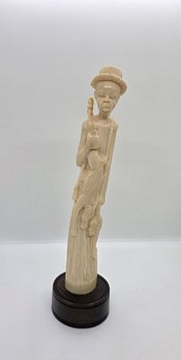 דמות גבר אפריקאי. מגולף בשן-הב, חומר טבעי. 
חוזר מציד ומחזיק ביד אחת ארנבת שניצודה זה עתה וביד 