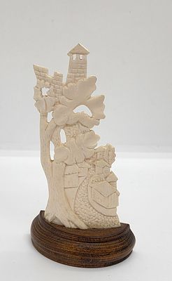 סצנה כפרית כנראה אפריקאית. גילוף בשן - הב. נתון על כן עץ. 
מידה: 11 על 6 סמ כולל בסיס