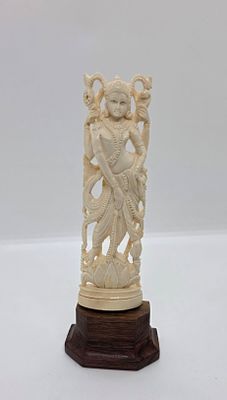 פסל יפהפה, של אלה כנראה הודית. עומדת על פרח הלוטוס. מגולף בחומר אורגני שן - הב. על מעמד מעץ. 