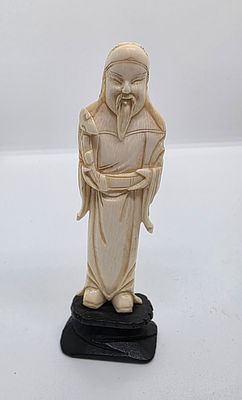 פסל של חכם סיני זקן עם שרביט. 
מגולף מחומר אורגני שן - הב. 
על בסיס מעץ. 
מידה כולל בסיס: 12.5 