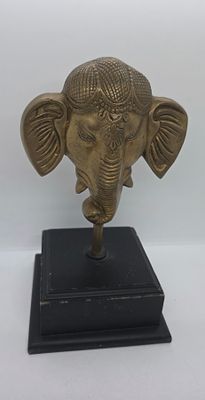 פסל מפליז של אלה הודית בדמות של ראש פיל, נתון על בסיס עץ. 
מידה כולל הבסיס : 28 על 