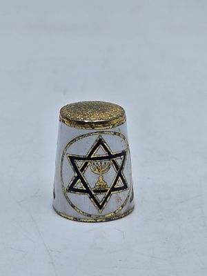 אצבעון אמייל עם סמלי המנורה ומגן דוד . 
כיתוב : ISRAEL 
2.5&times;2 ס"מ