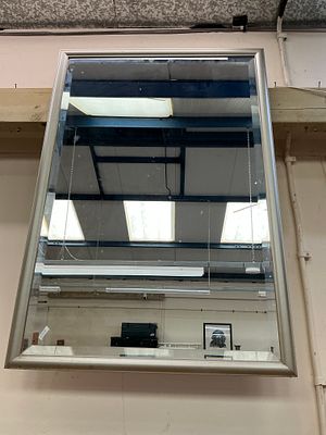 A large contemporary rectangular wall mirror with a stepped silver-toned frame and bevelled plate