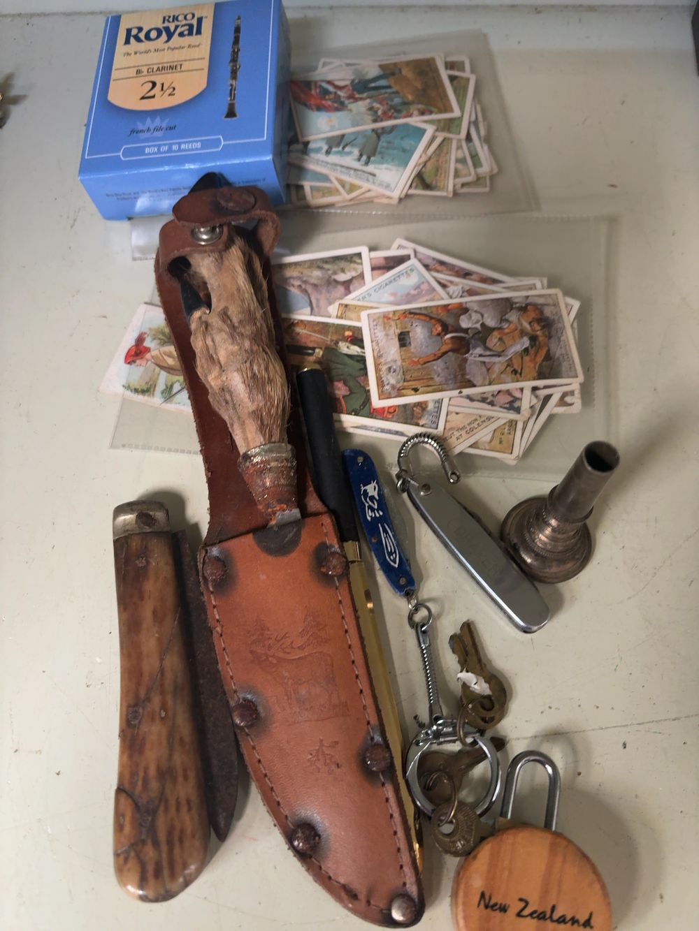 Lot 379: An Assortment of Vintage Collectibles including a Deer-Foot Hunting Knife, Cigarette Cards, and Musical Accessories