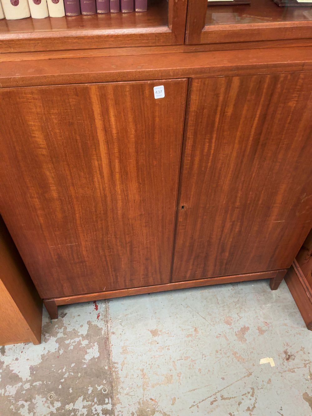 Lot 437: Mid-20th-century mahogany two-piece display cabinet on cupboard