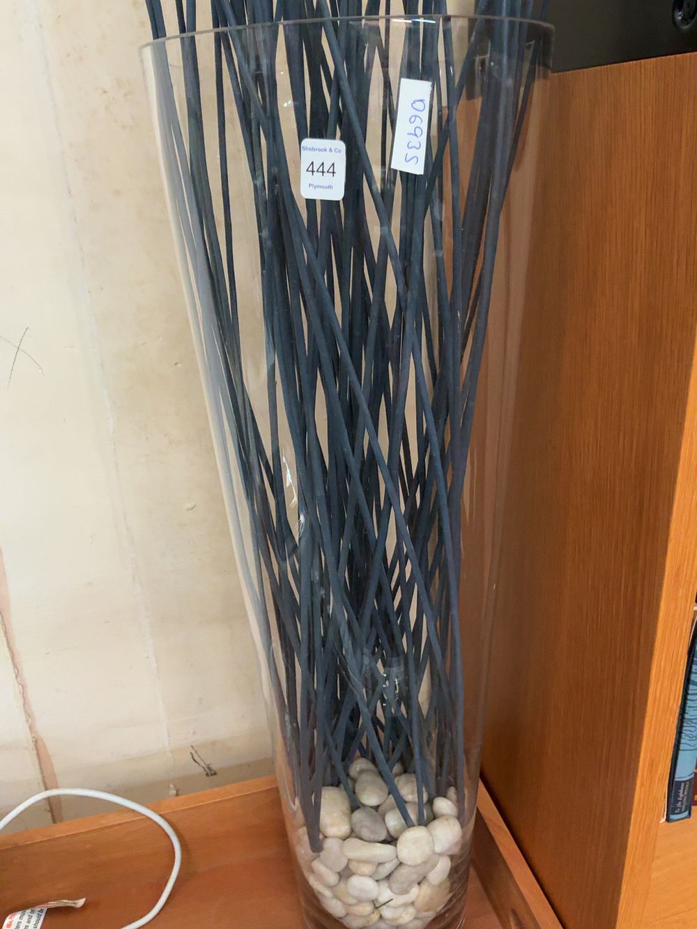 Lot 444: Large Tapered Clear Glass Floor Vase with Decorative Charcoal Sticks and White Pebbles