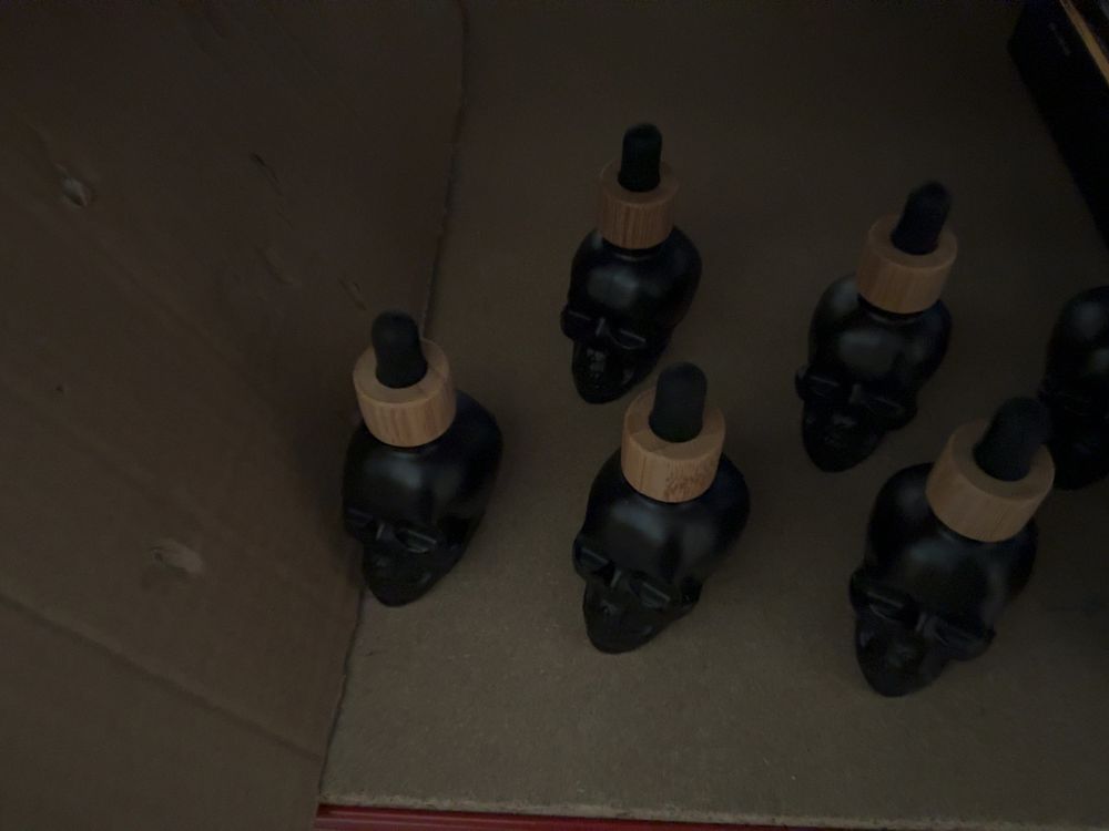 Lot 195: A Collection of Novelty Skull-Form Matte Black Glass Dropper Bottles