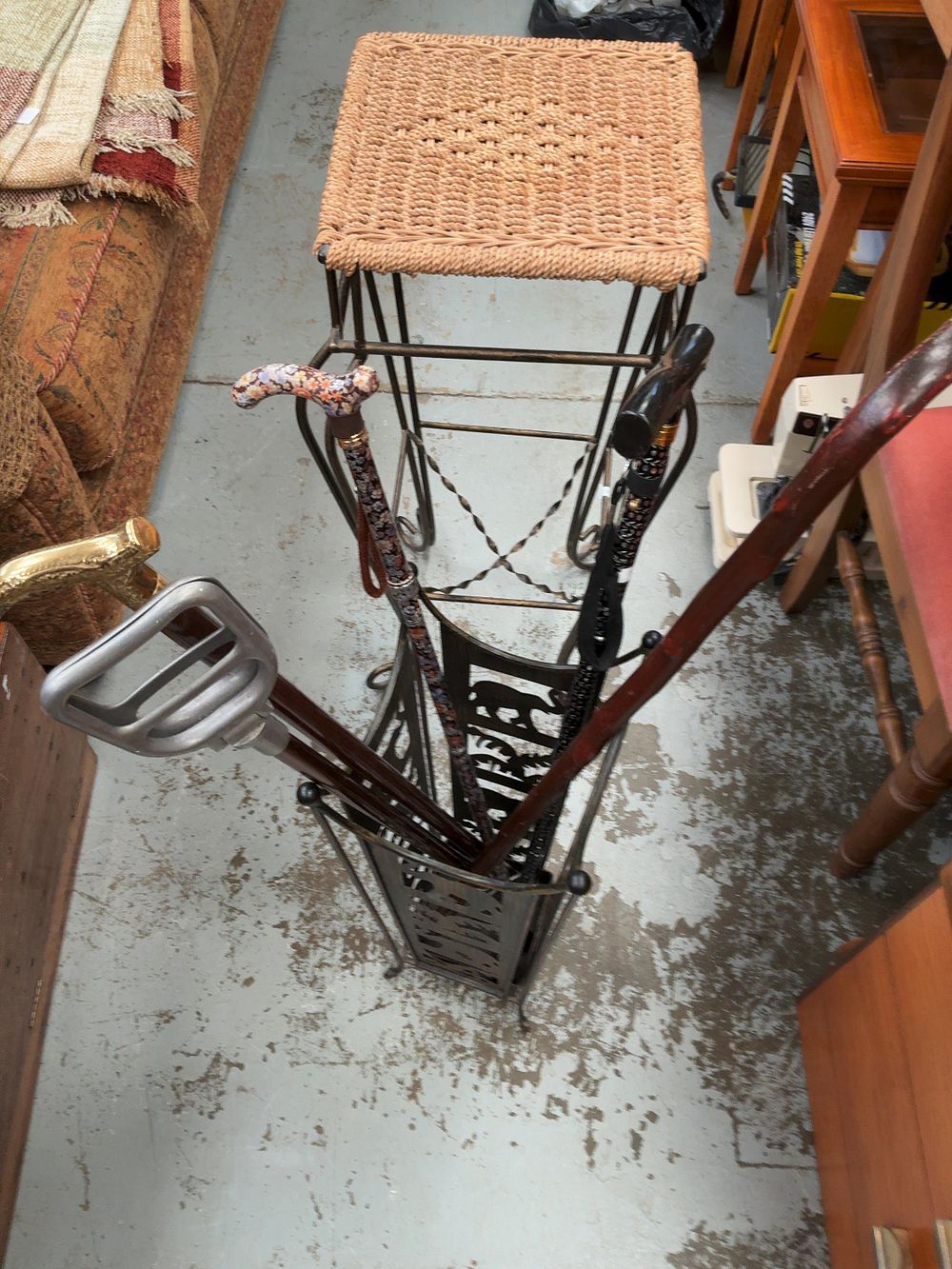 Lot 304: An Assortment of Walking Canes, an Elephant Motif Stand, a Woven-Topped Stool, linen basket  and a floor lamp.