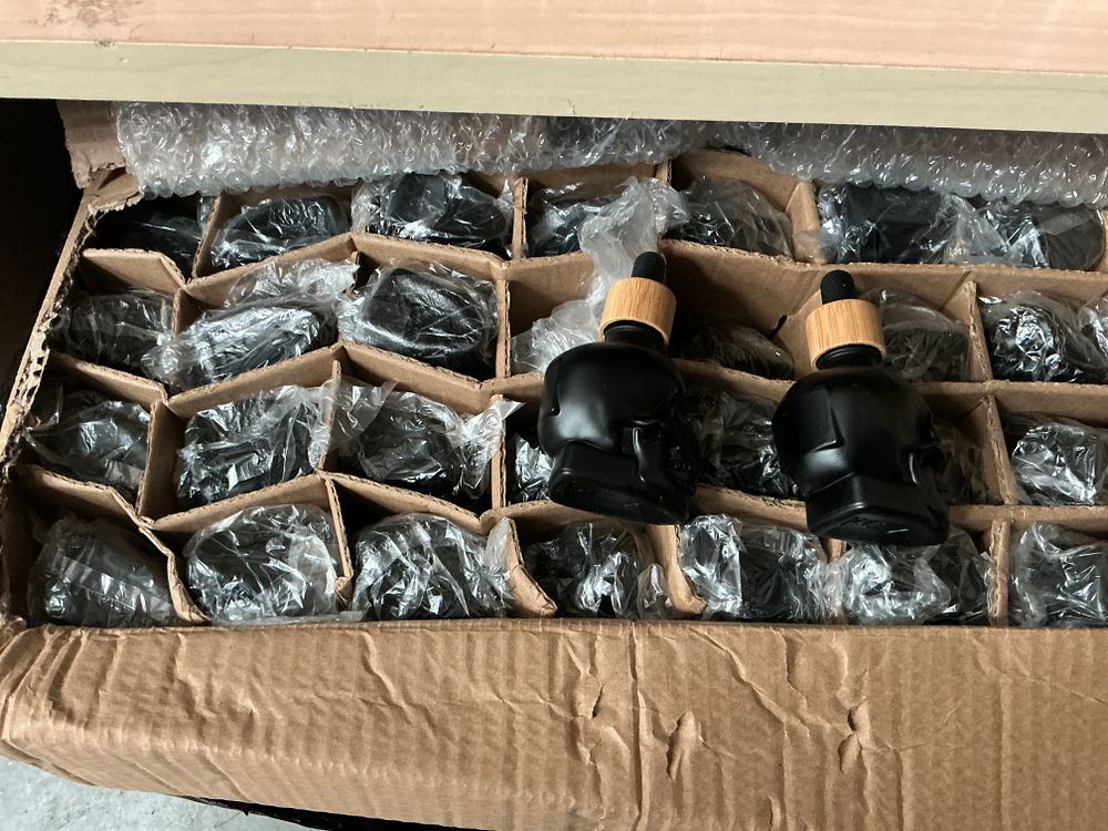 Lot 339: A Collection of Matte Black Glass Skull-Shaped Dropper Bottles