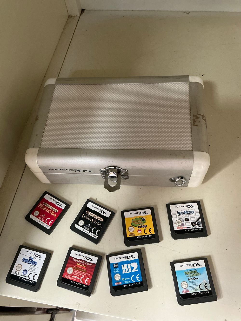 Lot 342: A Nintendo DS Handheld Games Console Group with Branded Aluminium Hard Shell Case and Game Cartridges
