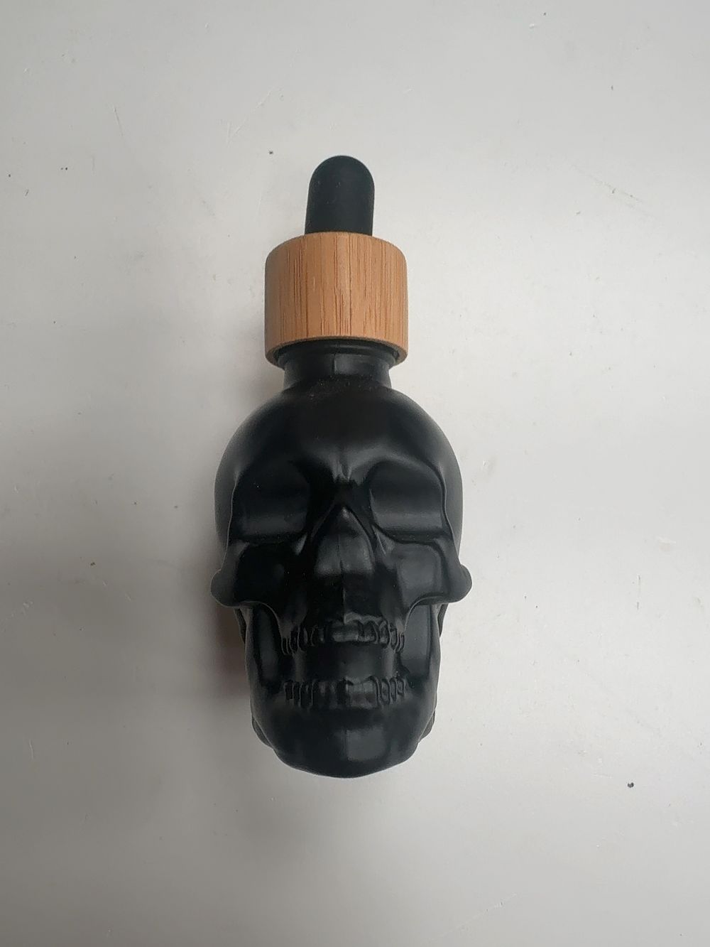 Lot 426: An Assortment of Contemporary Matte Black Glass Skull-Form Dropper Bottles