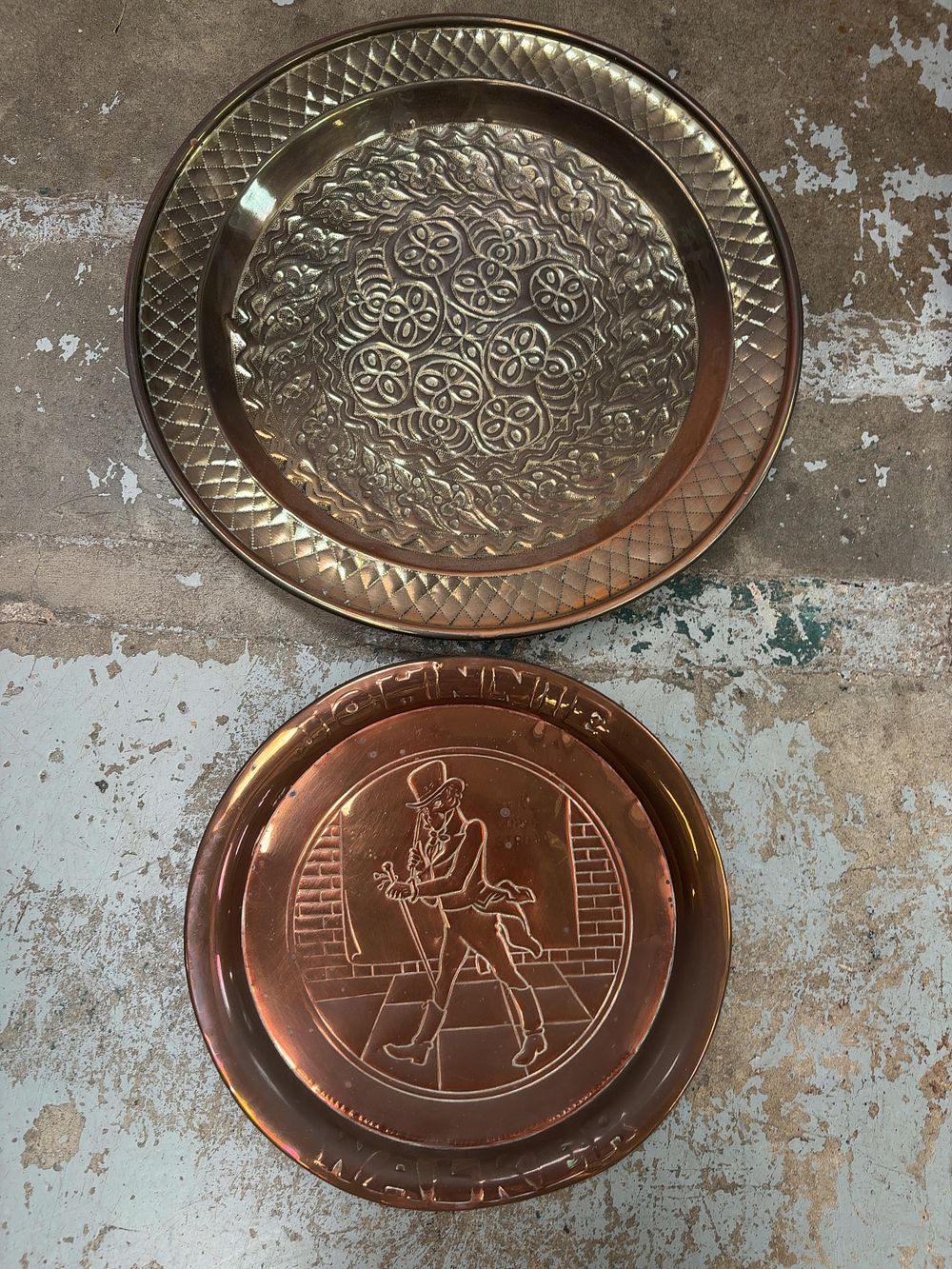 Lot 440: Two Circular Metal Trays comprising a Johnnie Walker Advertising Copper Plate and an Embossed Brass Tray
