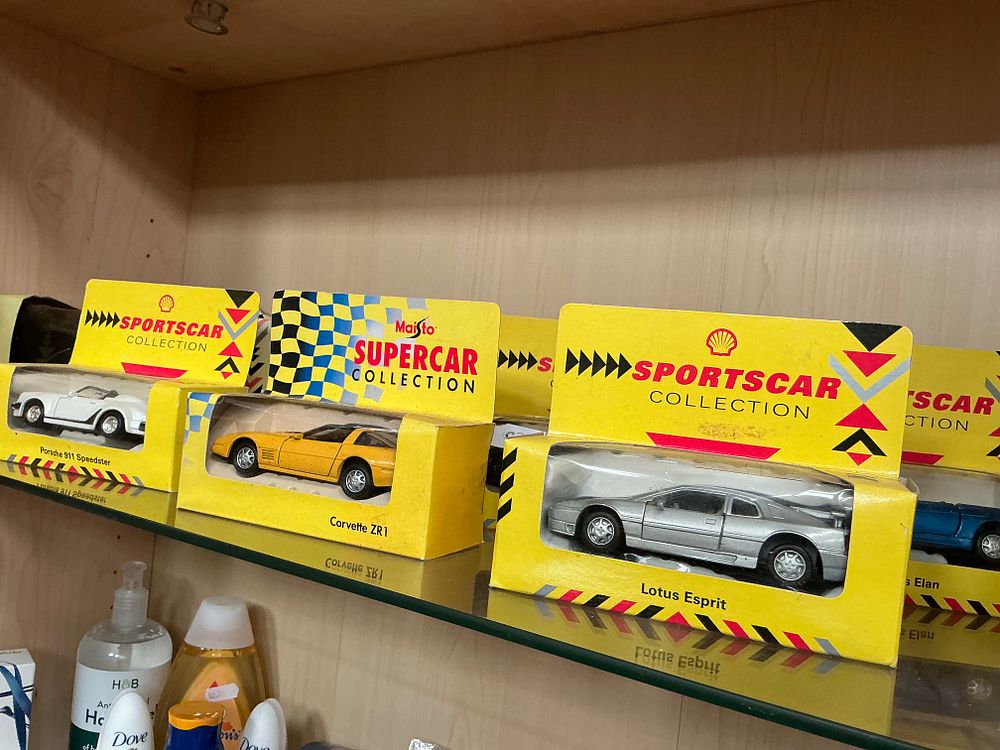 Lot 177: A Collection of Maisto Shell Promotional Model Cars
across 2 shelves