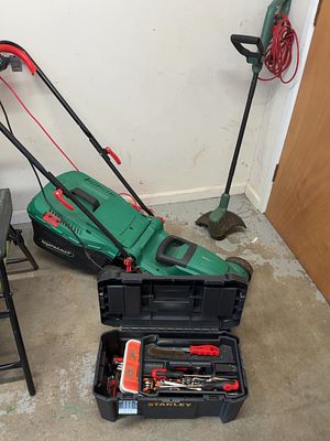 A collection of electric garden equipment and hand tools including a Qualcast lawn mower, a 