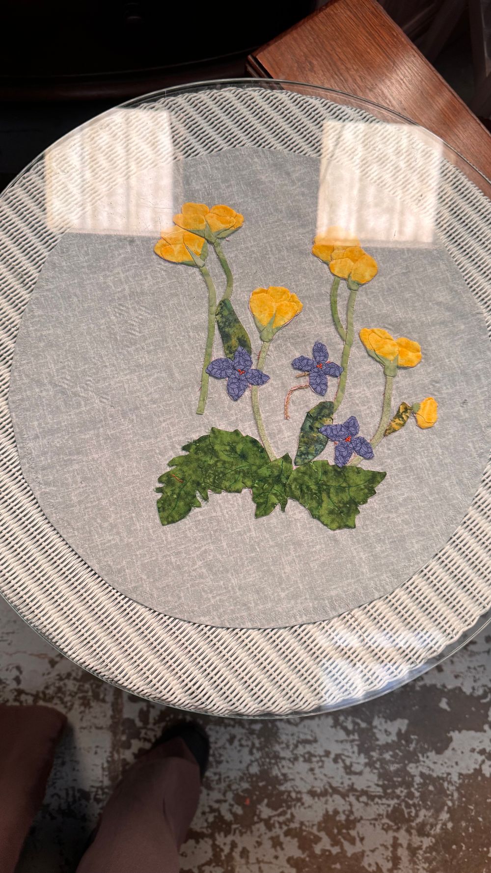 Lot 298: A Lloyd Loom Tub Chair, Occasional Table, and a Hand-Stitched Applique Textile Panel