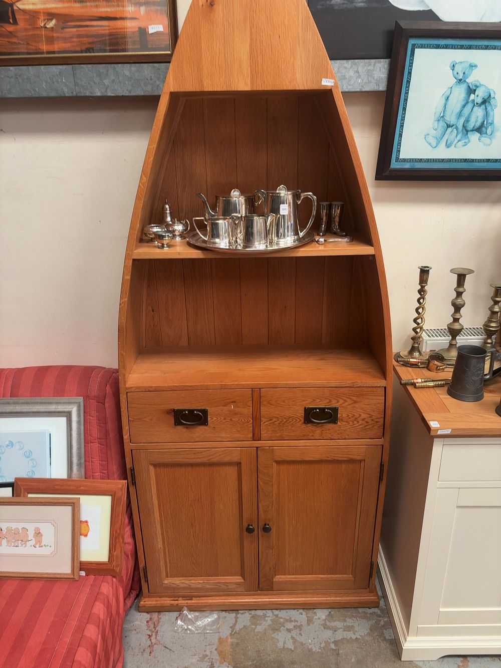 Lot 397: A contemporary oak boat-shaped display cabinet on a twin drawer and double door cupboard base