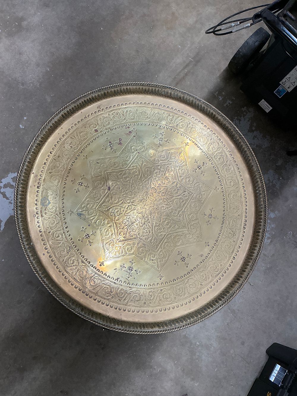 Lot 412: A 20th-century Moroccan style brass tray table on a folding wooden base