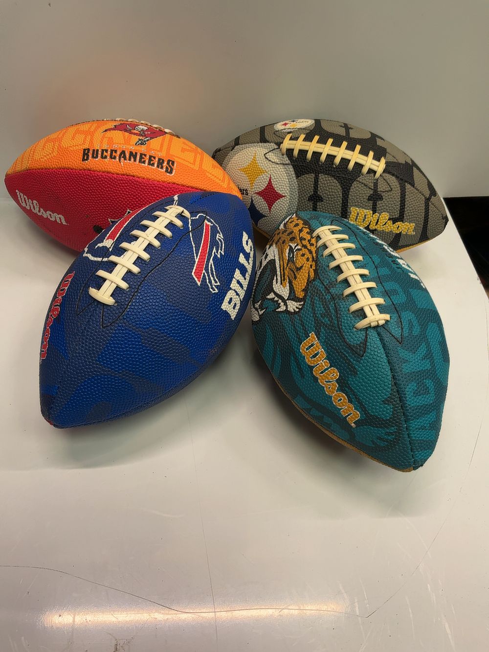 Lot 179: A collection of four Wilson NFL souvenir footballs