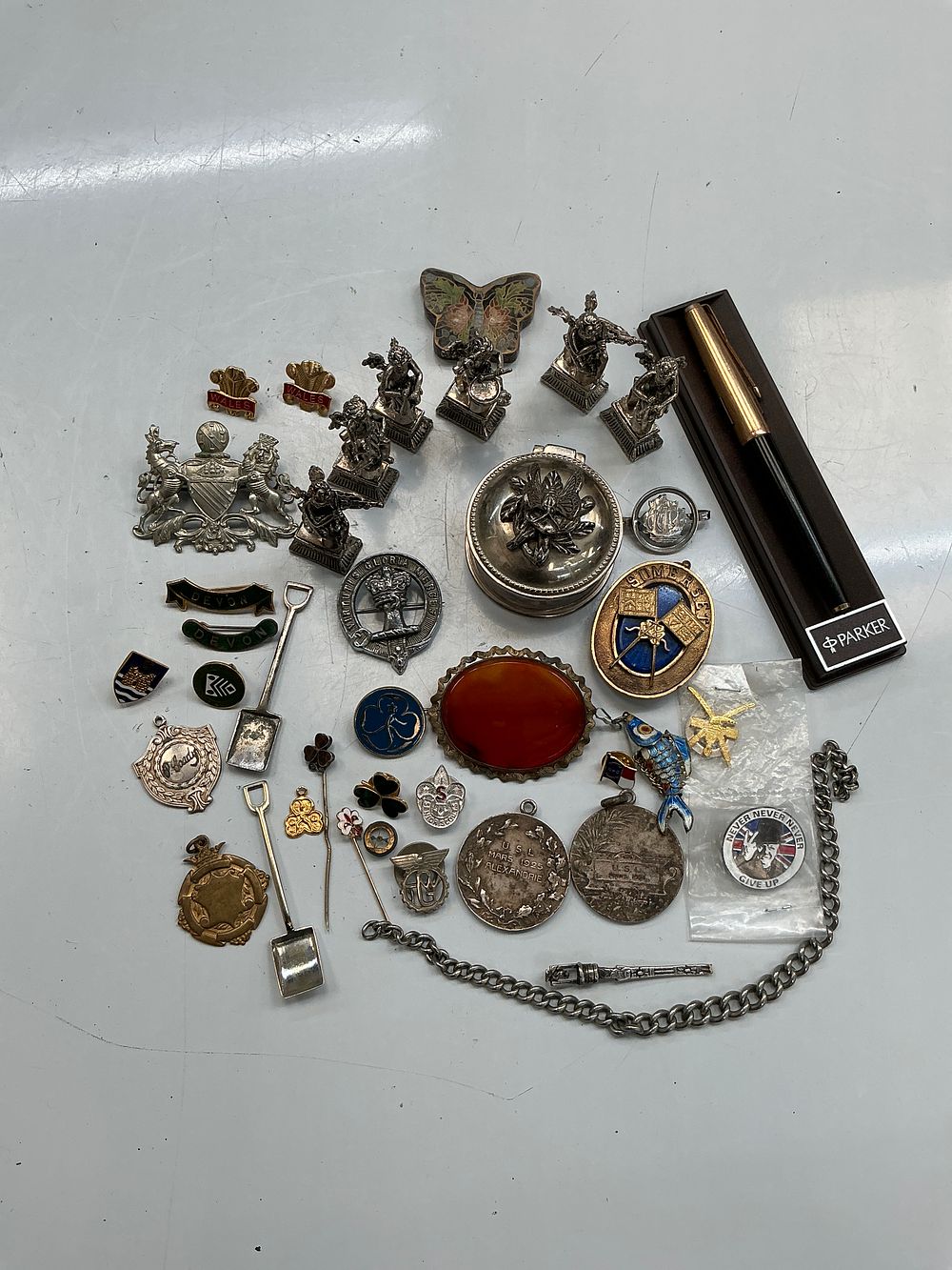 Lot 252: A Collection of Writing Instruments, Silver-Tone Miniatures, Enamel Badges, and Commemorative Medals