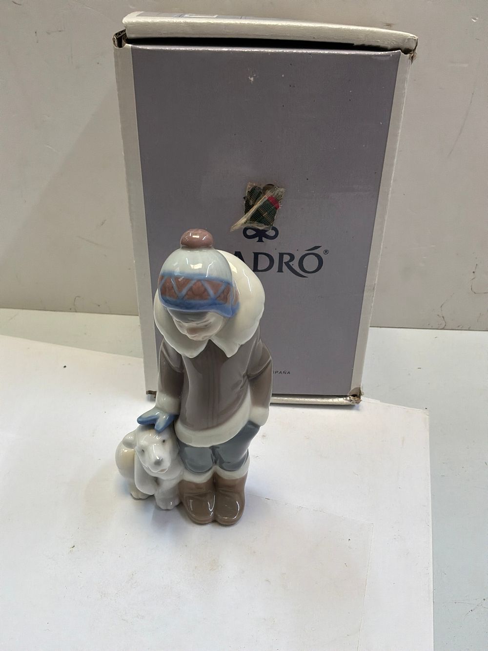 Lot 274: A Lladró Glazed Porcelain Eskimo Boy with Pet Figurine with Original Box
