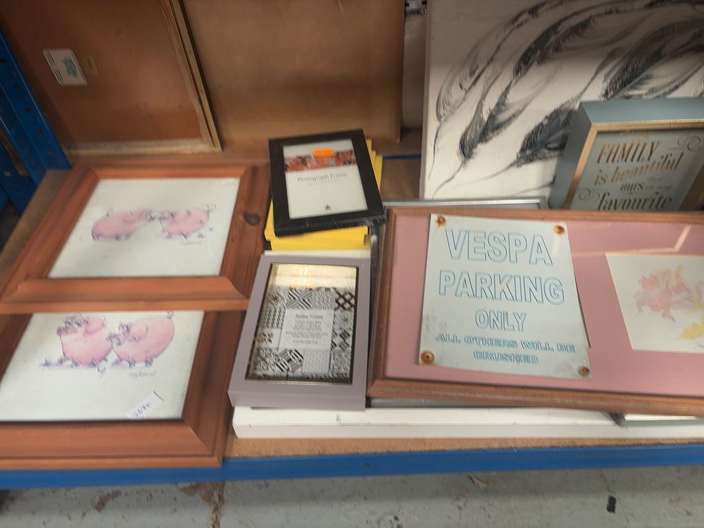 Lot 295: A Collection of Framed Wall Art and Decorative Signage Including The Simpsons and Vespa Examples