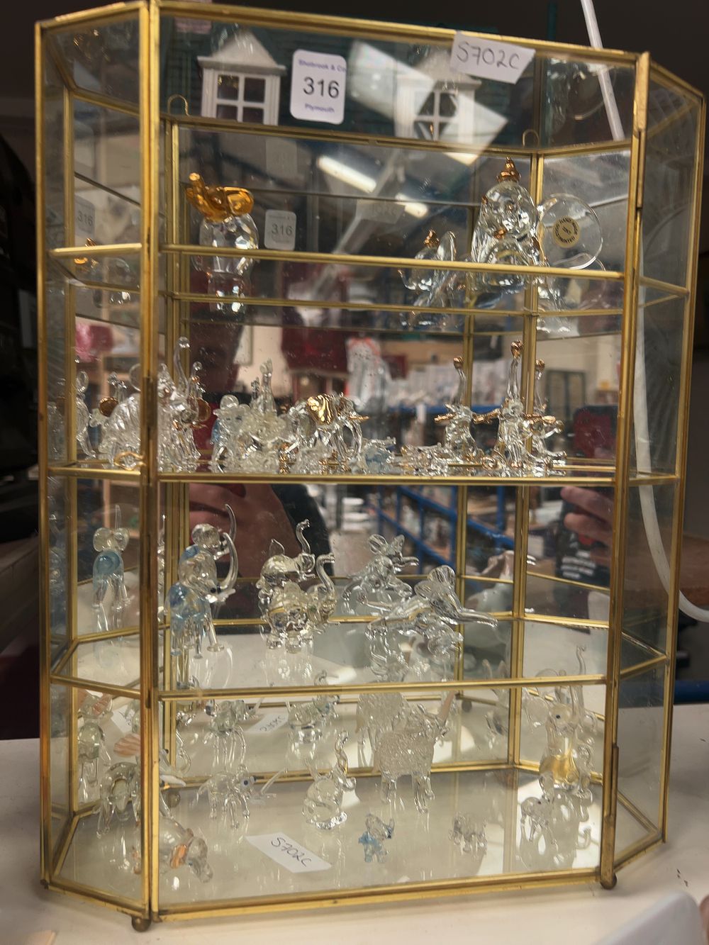 Lot 316: A Collection of Glass Elephant Figurines in a Brass Framed Display Case