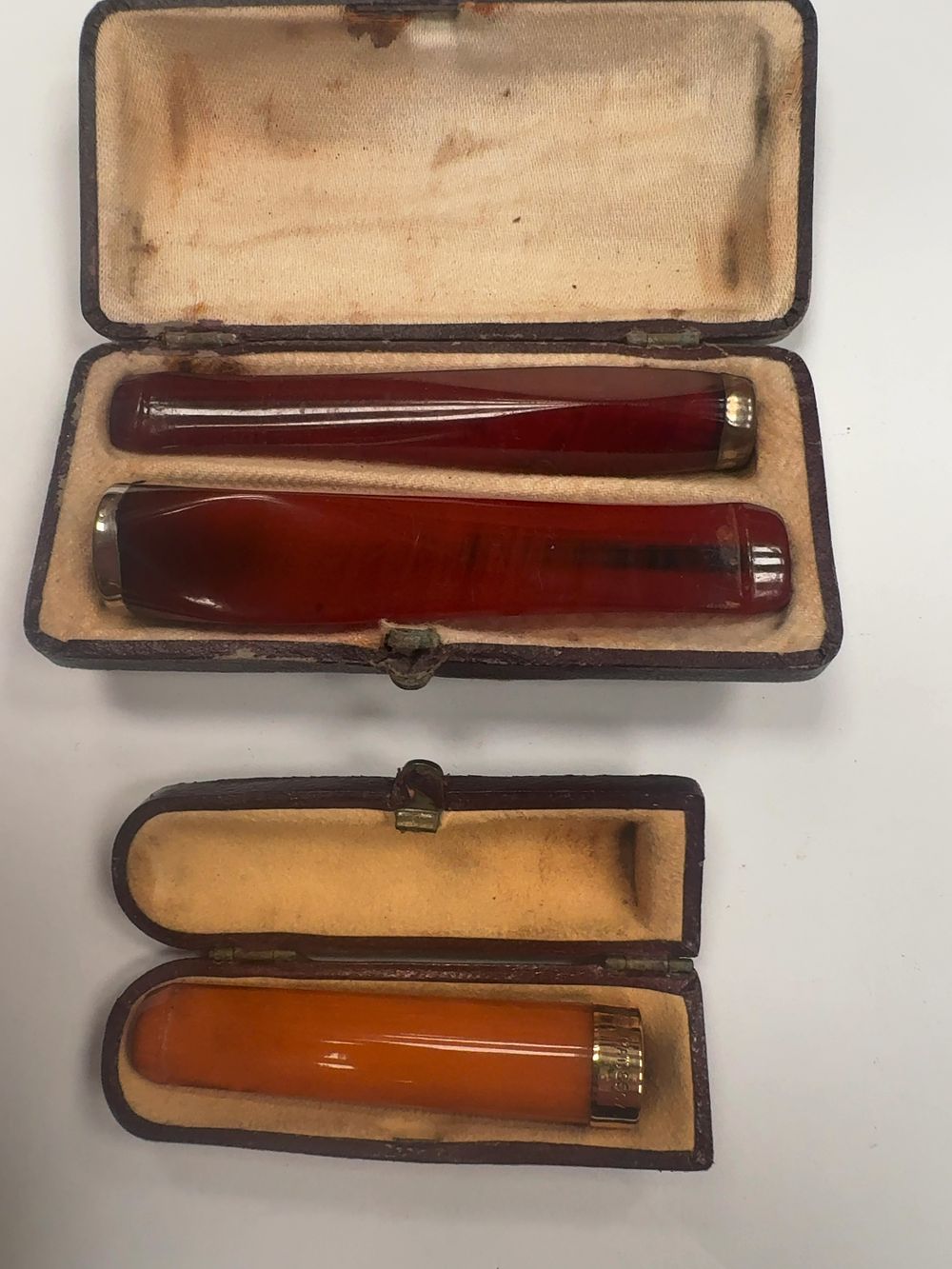 Lot 377: A Collection of Three Art Deco style Amber or Resin Cigar Holders in Two Fitted Cases