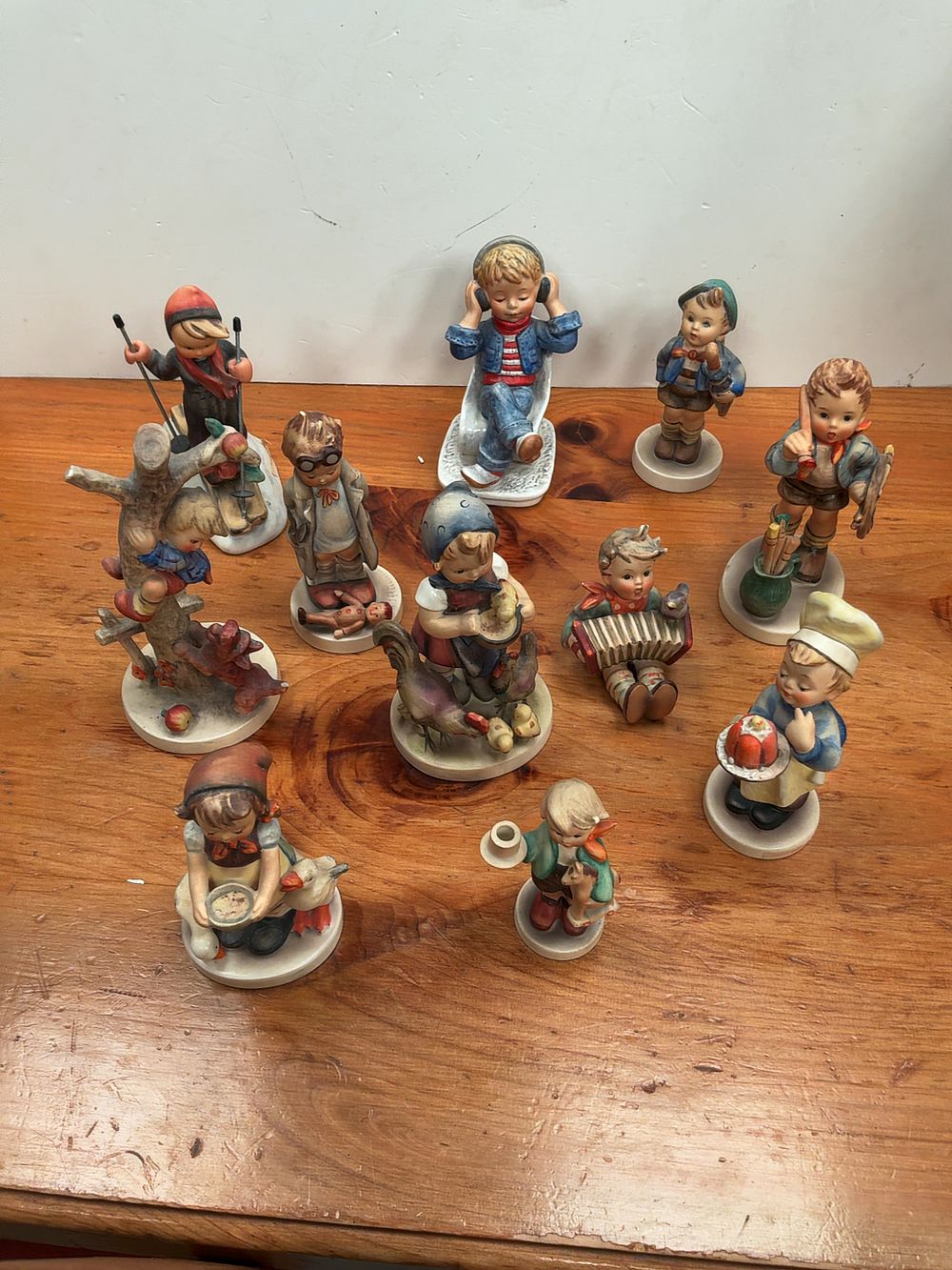 Lot 403: A Collection of Goebel Hummel Hand-Painted Ceramic Figurines including Today's Children and Skier Examples