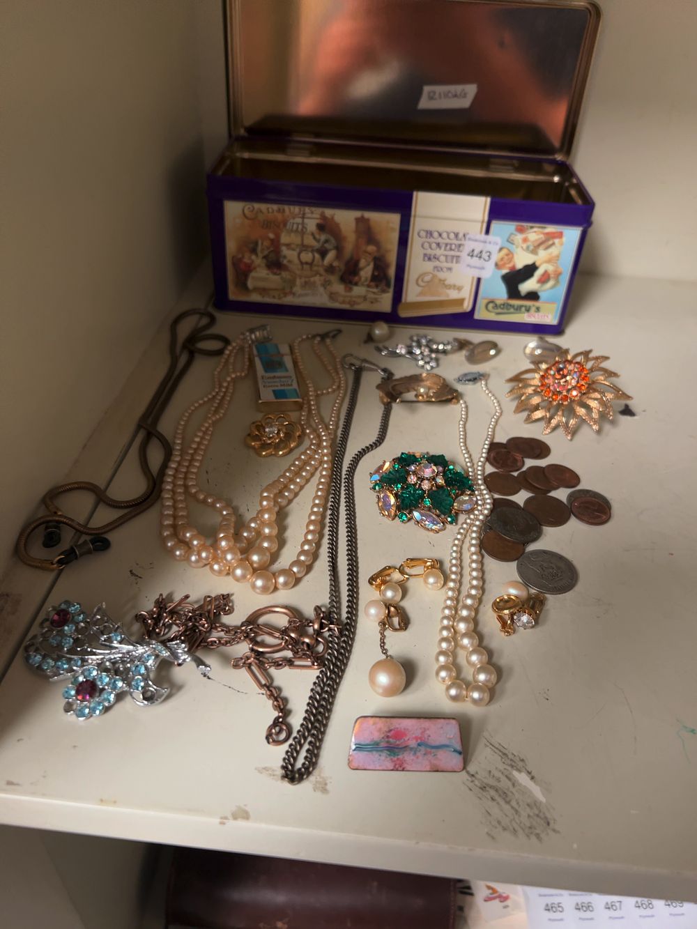 Lot 443: A Collection of Vintage Costume Jewellery, British Coins and a Cadbury's Biscuit Tin.