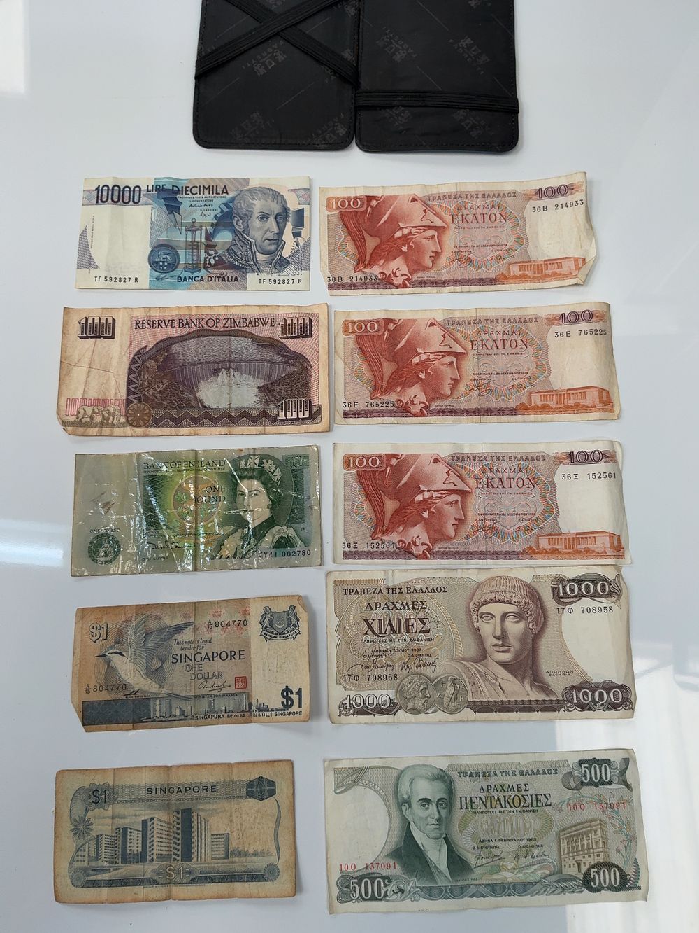Lot 50: A Collection of International Banknotes Including Examples from Italy, Greece, Zimbabwe, Singapore, and the UK