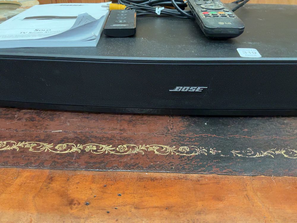 Lot 319: A Bose Solo TV Sound System with Two Remotes and Cables