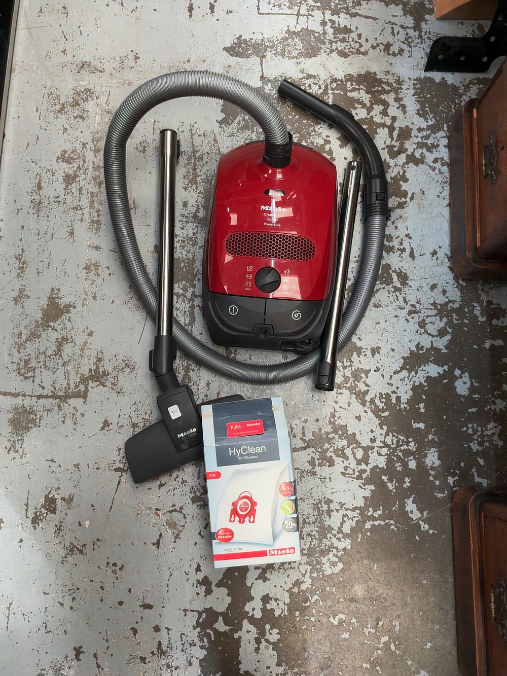 Lot 322: A Miele Plastic Canister Vacuum Cleaner with Accessories and Dust Bags