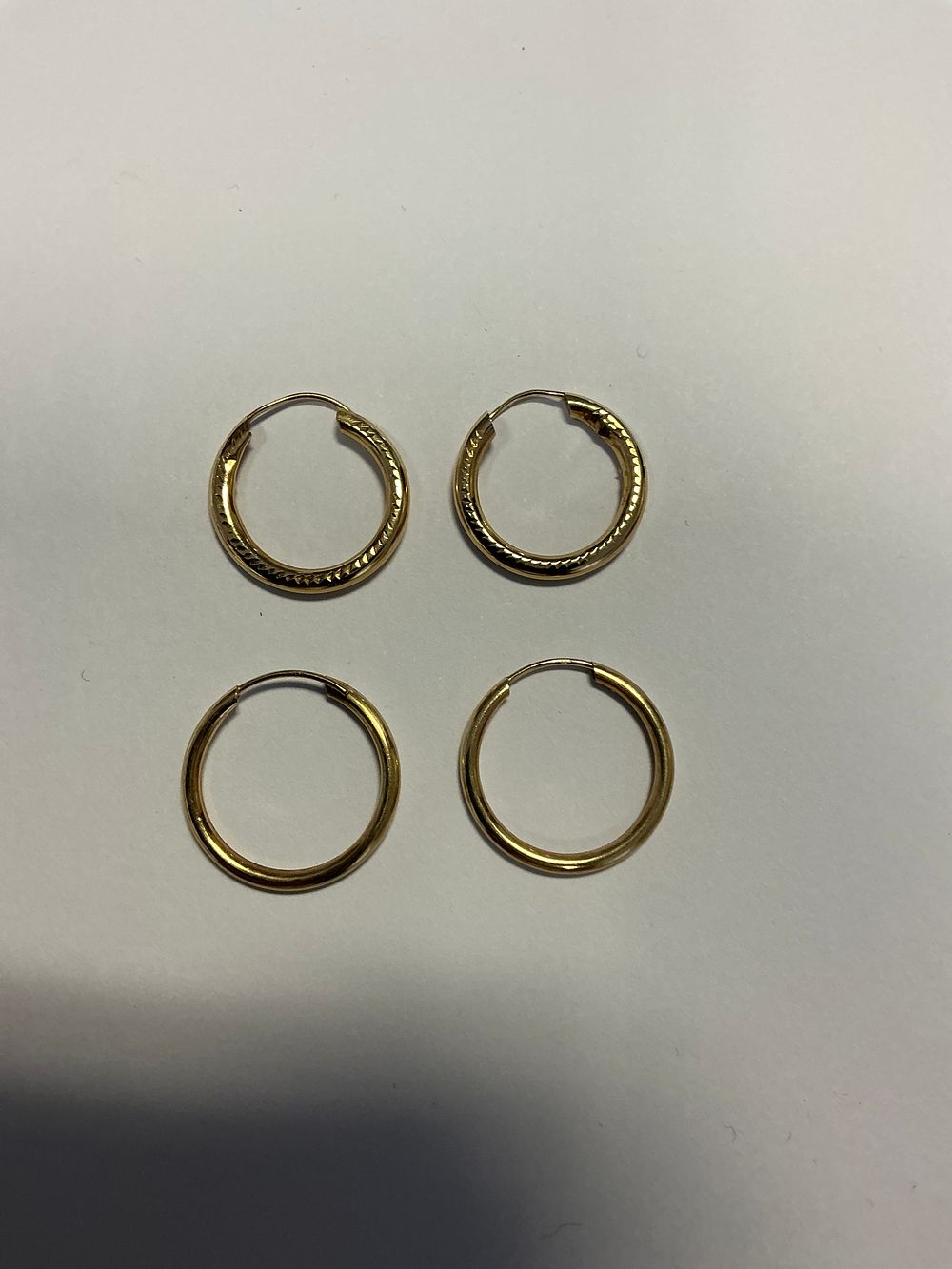 Lot 127: A Group of Two Pairs of Yellow Metal Hoop Earrings