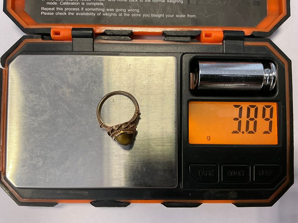 Lot 134: A 9ct Yellow Gold and Tiger's Eye Cabochon Dress Ring