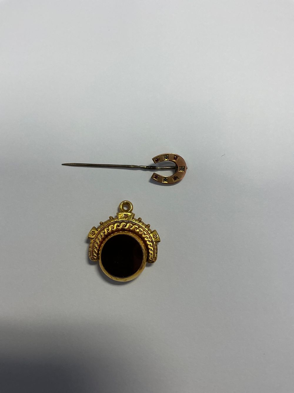 Lot 165: A Two Piece Collection of Jewellery Including a 9ct Gold Spinner Fob and a Horseshoe Stick Pin