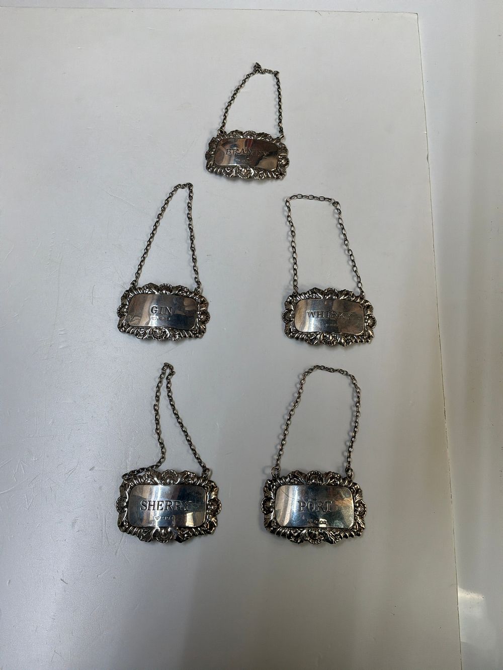 Lot 181: A Set of Five Mid Century Sterling Silver Decanter Labels by Albert Cohen and Solomon Samuel