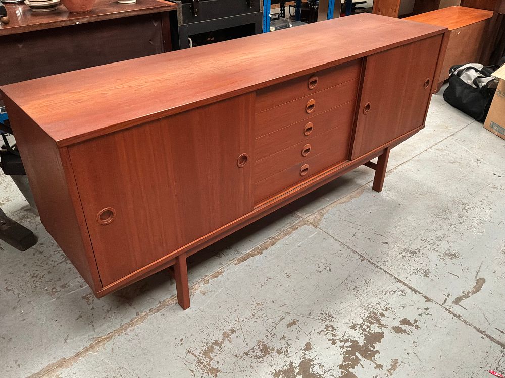 Lot 402: A Mid-Century Modern Teak Sideboard with Sliding Doors and Five Central Drawers