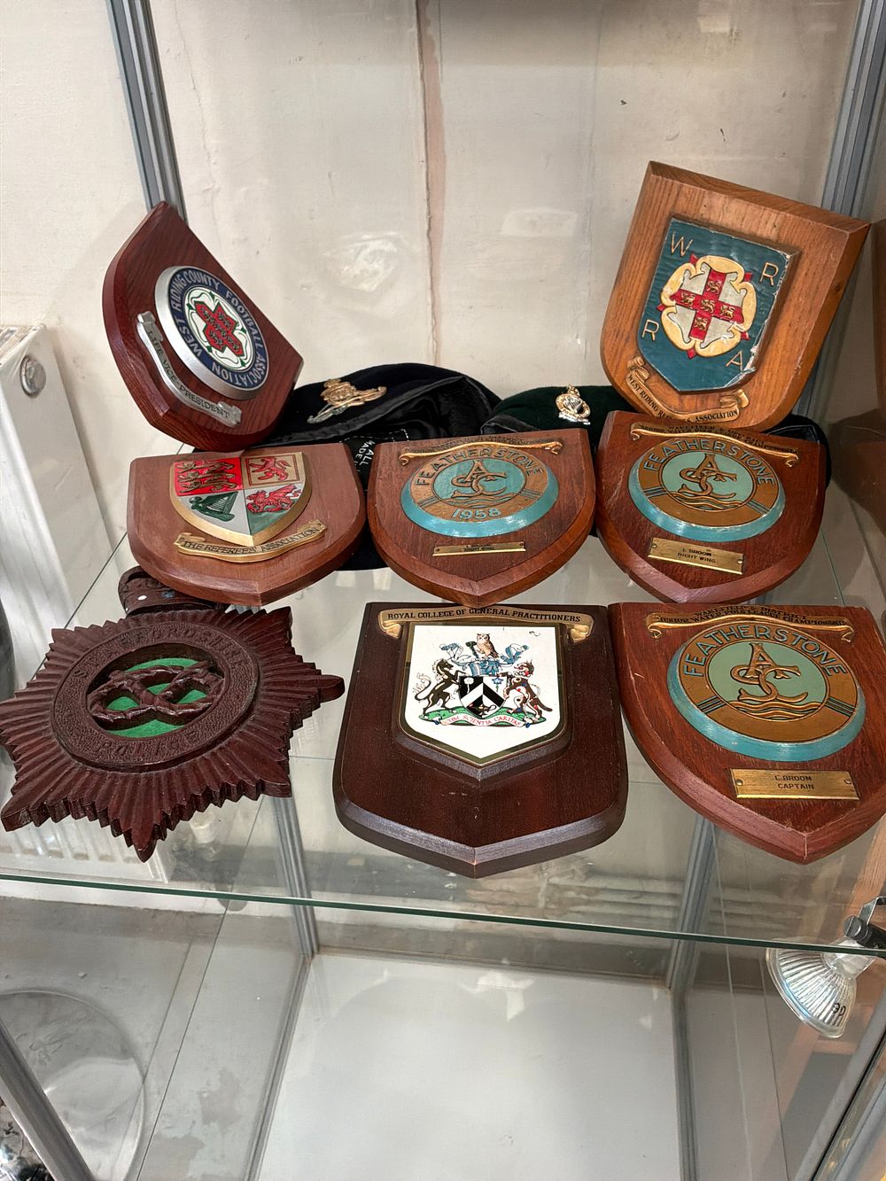 Lot 499: A Collection of Sports and Professional Commemorative Shields with Two Military Style Berets