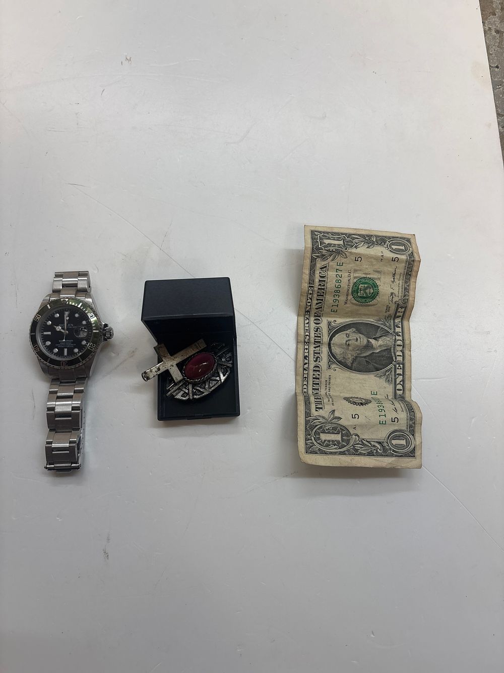 Lot 300: A Mixed Lot Comprising A Replica Rolex Submariner Date Wristwatch a Religious Jewellery Trio and a United States One Dollar Bill