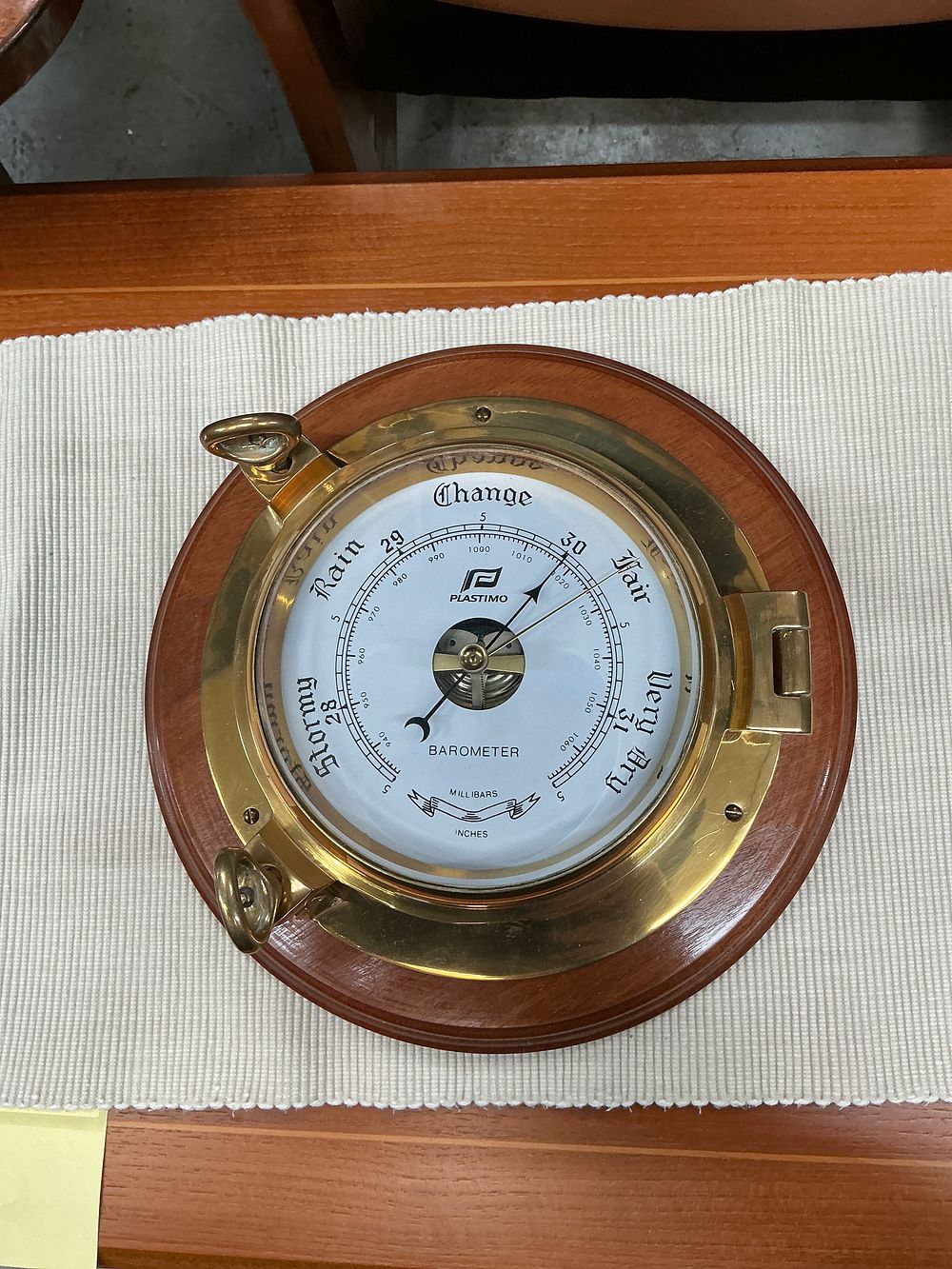 Lot 253: A Plastimo Polished Brass Porthole Style Aneroid Barometer on Wooden Mount
