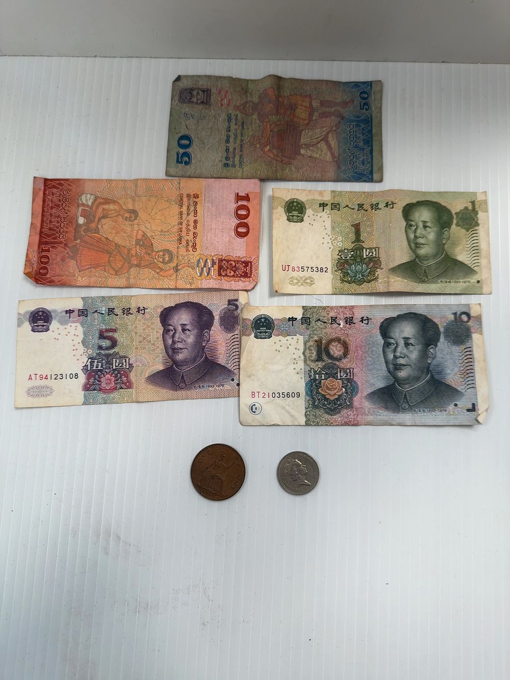 Lot 266: A Collection of Five International Banknotes and Two UK Coins