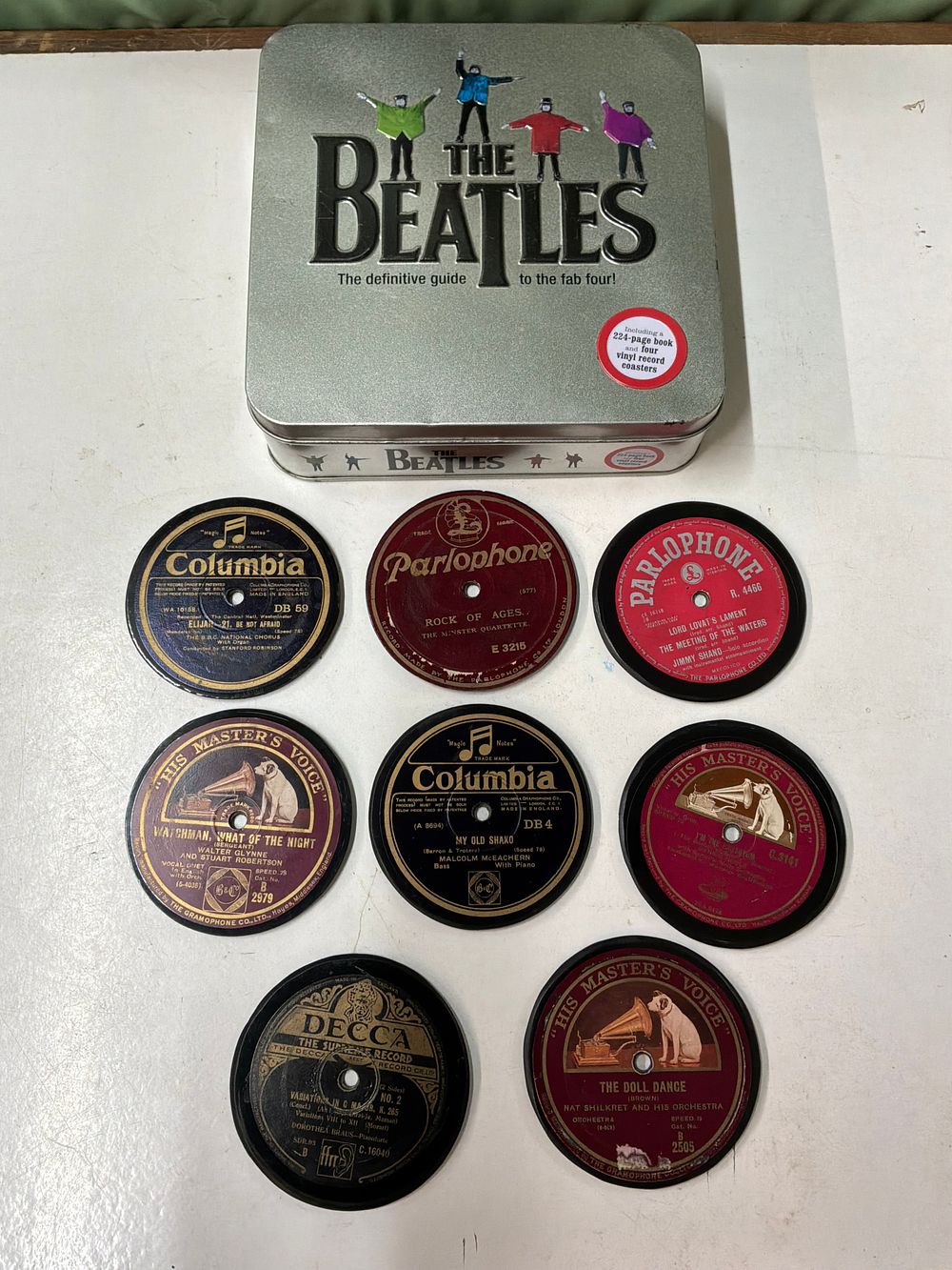 Lot 380: A Beatles Definitive Guide To The Fab Four Tin Set and a Collection of Eight Vintage Style Record Coasters